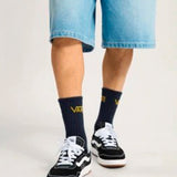 Persona con shorts de mezclilla y zapatillas Vans Cruze 3.0 negras