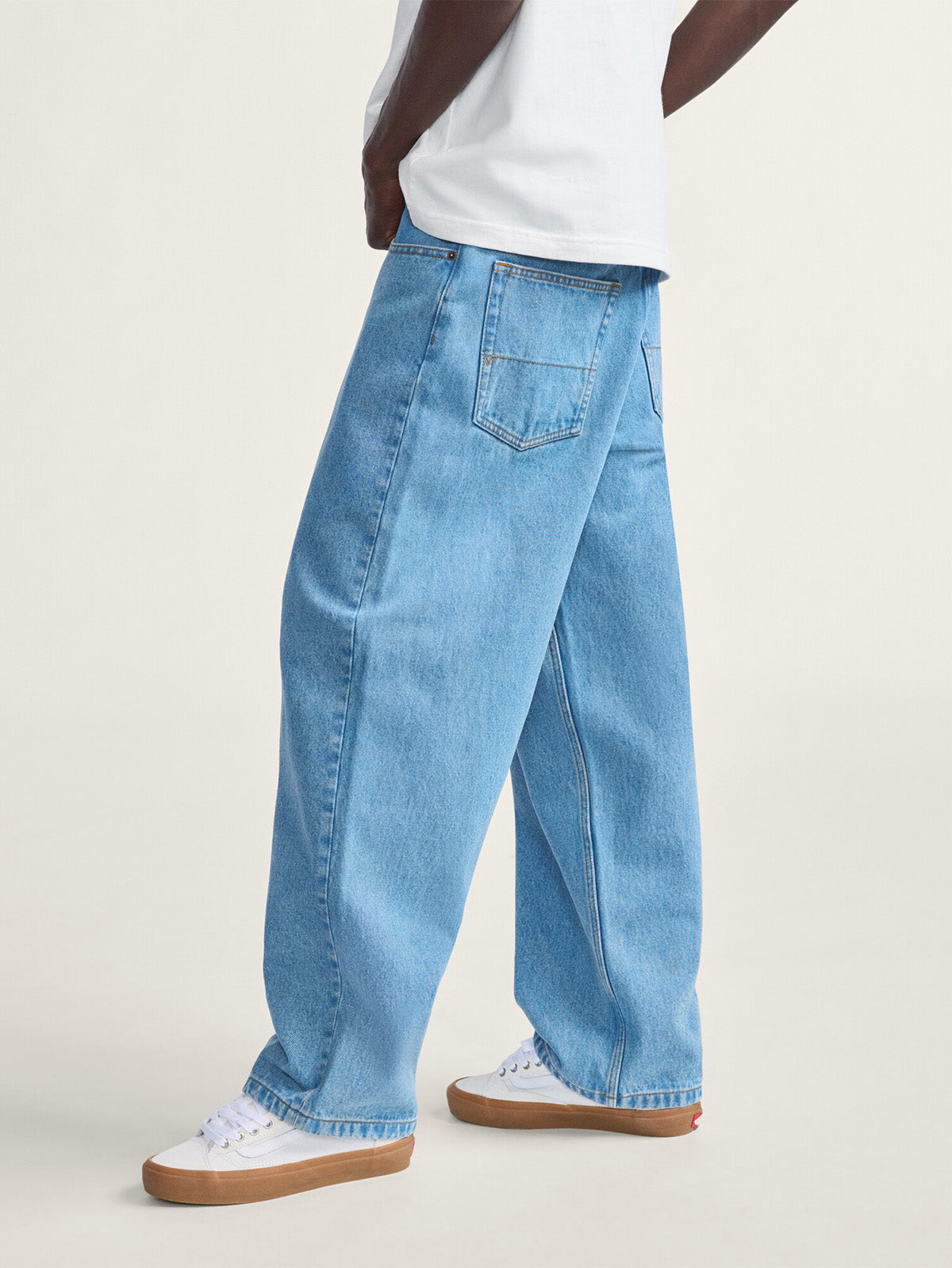 Hombre con el jeans Vans baggy azul claro, vista lateral trasera