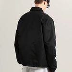 Hombre con la chaqueta coach Vans negra, vista de espalda