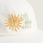 Detalle del sol naranjo y Off the Wall en verde del jockey blanco